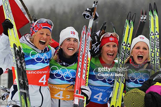 Vibeke W Skofterud, Kristin Stoermer Steira, Marit Bjoergen and Therese Johaug of Norway celebrate after winning the gold medal during the Ladies'...