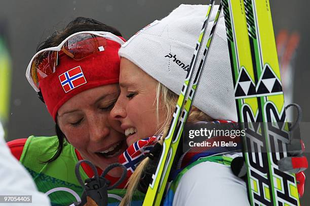 Marit Bjoergen of Norway celebrates with Therese Johaug after Norway won the gold medal during the Ladies' Cross Country 4x5 km Relay on day 14 of...