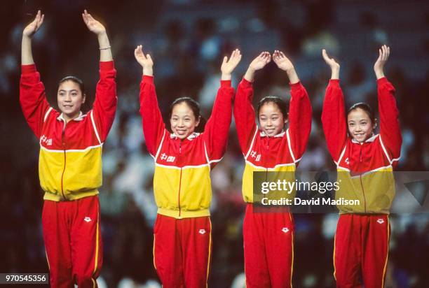 Wenjing Wang, Xia Zhang, Wenning Zhang, and Li Li of the China Women's Gymnastics Team wave to the crowd during the awards ceremony for the team...