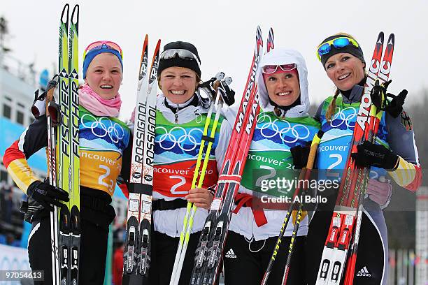 Miriam Gossner, Katrin Zeller, Evi Sachenbacher-Stehle and Claudia Nystad of Germany celebrate winning the silver medal during the Ladies' Cross...