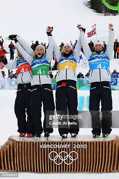 Vibeke W Skofterud, Therese Johaug, Kristin Stoermer Steira and Marit Bjoergen of Norway celebrate after winning the gold medal during the Ladies'...