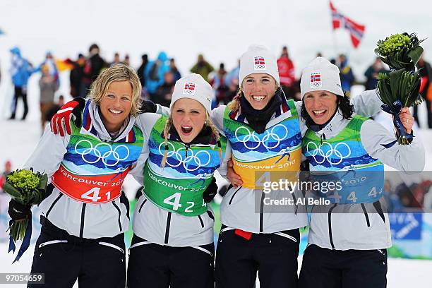 Vibeke W Skofterud, Therese Johaug, Kristin Stoermer Steira and Marit Bjoergen of Norway celebrate after winning the gold medal during the Ladies'...