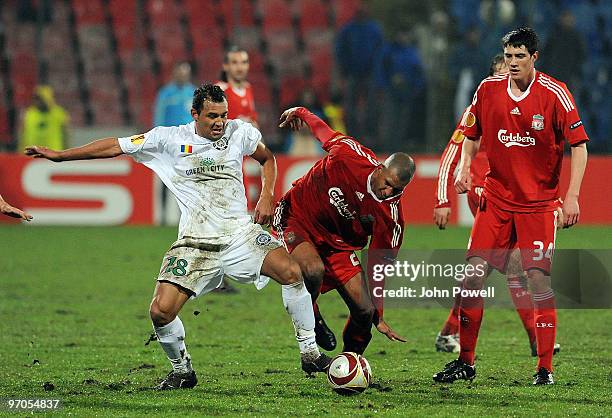 David Ngog of Liverpool competes with Ricardo Vilana of Unirea Urziceni during the UEFA Europa League knock-out round, second leg match between FC...