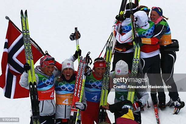 Vibeke W Skofterud, Kristin Stoermer Steira, Marit Bjoergen and Therese Johaug of Norway celebrate after winning the gold medal during the Ladies'...