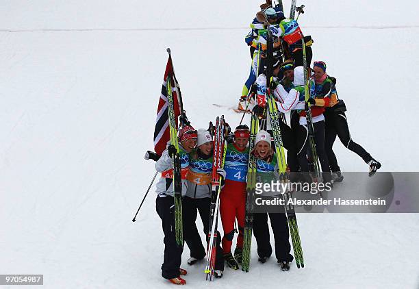 Vibeke W Skofterud, Kristin Stoermer Steira, Marit Bjoergen and Therese Johaug of Norway celebrate after winning the gold medal with silver medalists...