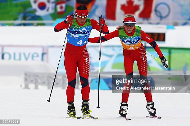 Kristin Stoermer Steira of Norway hands over to Marit Bjoergen during the Ladies' Cross Country 4x5 km Relay on day 14 of the 2010 Vancouver Winter...