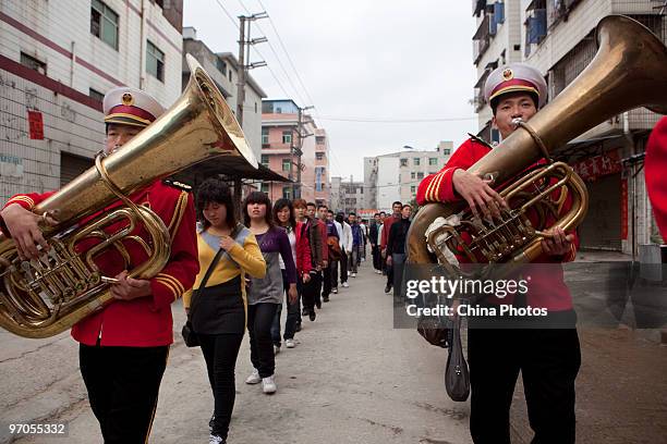 Band members welcome new migrant workers at the Shenzhen Quanshun Human Resources Co., Ltd, on February 23, 2010 in Shenzhen of Guangdong Province,...