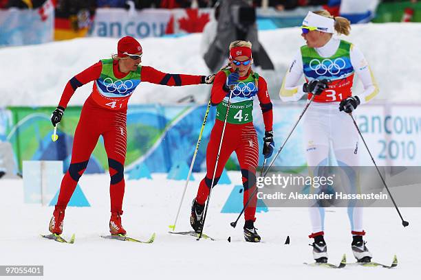 Vibeke W Skofterud of Norway hands over to Therese Johaug during the Ladies' Cross Country 4x5 km Relay on day 14 of the 2010 Vancouver Winter...