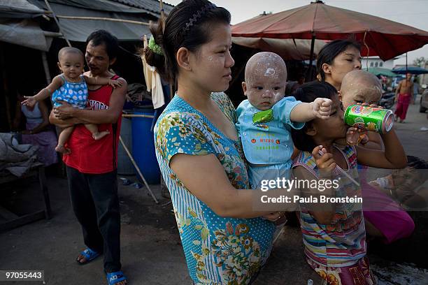 Burmese mothers and their children stand in a market place in a Burmese community where many work in the seafood industry February 25, 2010 in...