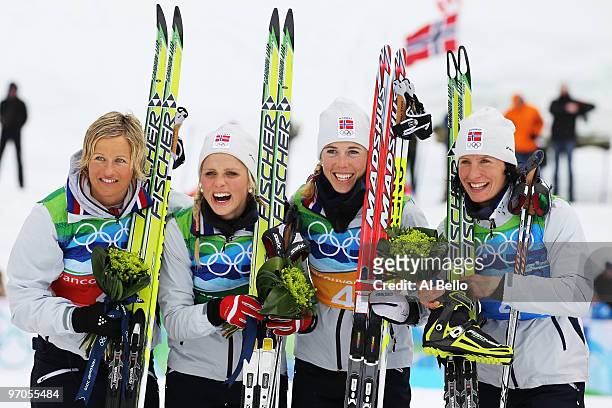 Vibeke W Skofterud, Therese Johaug, Kristin Stoermer Steira and Marit Bjoergen of Norway celebrate after winning the gold medal during the Ladies'...