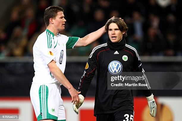 Alexander Madlung of Wolfsburg shakes hands with team mate Marwin Hitz during the UEFA Europa League knock-out round, second leg match between VfL...