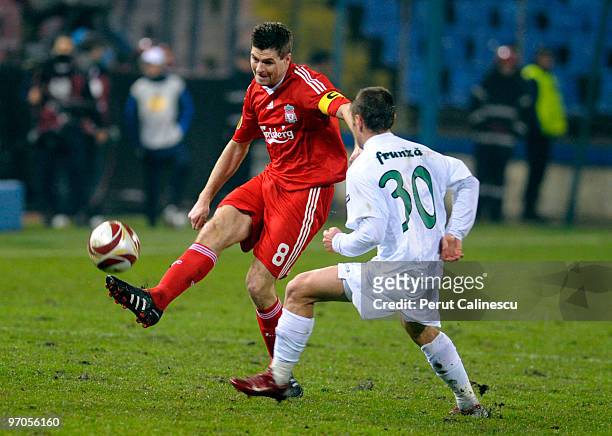 Captain Steven Gerrard of Liverpool competes with Sorin Frunza of Unirea Urziceni during the UEFA Europa League Round of 32, 2nd leg match between FC...