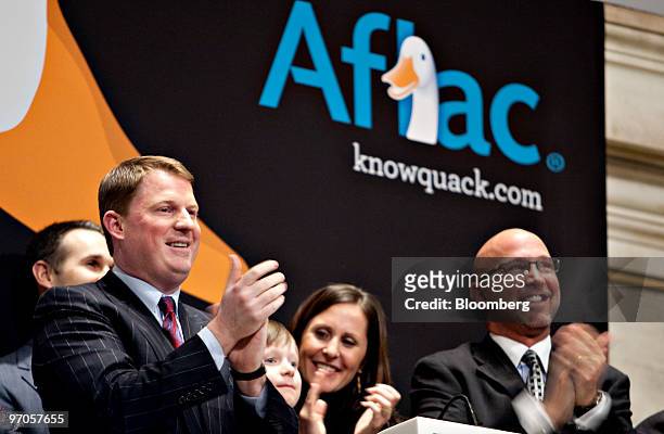 Paul Amos, president and chief operating officer of Aflac Inc., left, participates in the closing bell ceremony on the floor of the New York Stock...