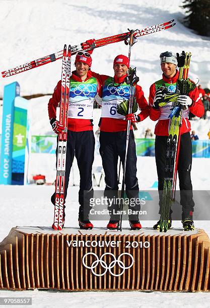 Johnny Spillane of the United States celebrates winning silver, Bill Demong of the United States gold and Bernhard Gruber of Austria bronze during...