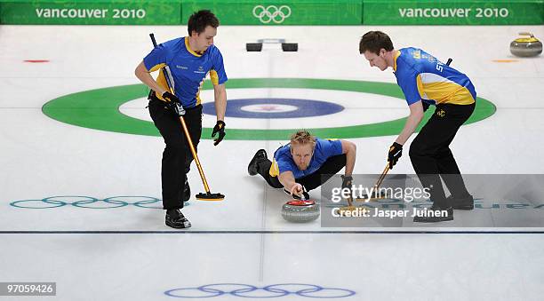 Skip Niklas Edin of Sweden releases the stone flanked by his teammates Fredrik Lindberg and Viktor Kjaell during the men's curling semifinal game...