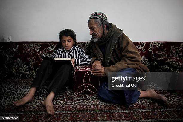 Nine-year-old Yemeni Jew Salim Moussa reads the Torah with Yusuf Moussa Salim inside a protected compound in Sana'a named Tourist City on January 20,...