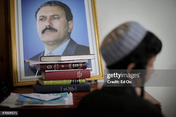 Nine-year-old Yemeni Jew Salim Moussa stands beside a portrait of president Ali Abdullah Saleh and religious books inside a protected compound in...
