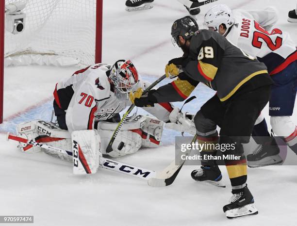 Braden Holtby of the Washington Capitals covers up a shot by Colin Miller of the Vegas Golden Knights as Alex Tuch of the Golden Knights tries for a...