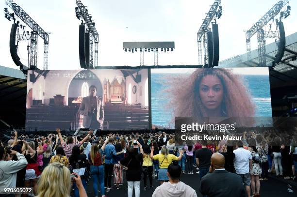 Crowds take photos with their mobile phones as images of Beyonce and Jay-Z are projected before they appear to perform on stage during the "On the...