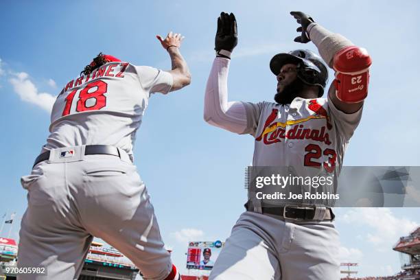 Marcell Ozuna of the St. Louis Cardinals celebrates with Carlos Martinez after hitting a solo home run in the first inning against the Cincinnati...