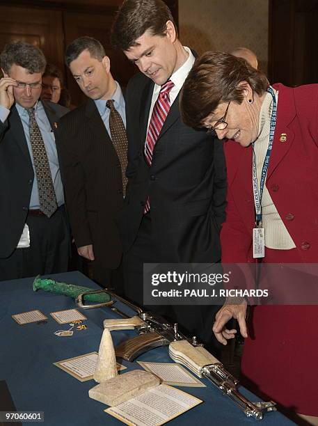 Immigration and Customs Enforcement Ass't Sec John Morton and ICE official Pat Reilly look over cultural items recovered by ICE during a ceremony...