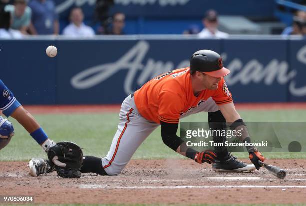 Craig Gentry of the Baltimore Orioles takes an emergency swing to foul off and spoil a low pitch on a suicide squeeze in the ninth inning during MLB...
