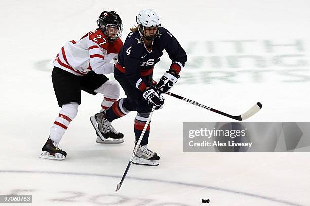 Angela Ruggiero of the United States is challenged by Gina Kingsbury of Canada during the ice hockey women's gold medal game between Canada and USA...