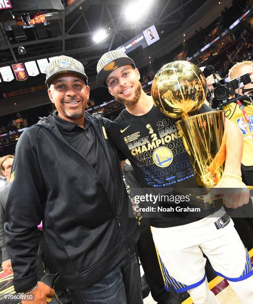 Stephen Curry of the Golden State Warriors poses with Larry O'Brien Championship Trophy and former NBA player Dell Curry after the win against the...