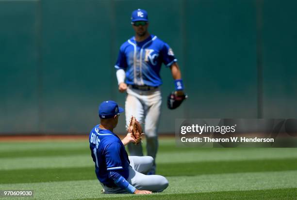 Ryan Goins of the Kansas City Royals goes into a slide making a catch over his shoulders to take a hit away from Marcus Semien of the Oakland...