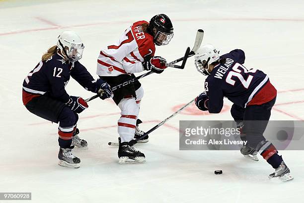 Cherie Piper of Canada is closed down by Jenny Potter and Kerry Weiland of the United States during the ice hockey women's gold medal game between...