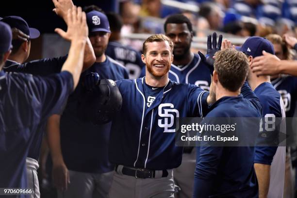 Cory Spangenberg of the San Diego Padres is congratulated by teammates after scoring in the first inning against the Miami Marlins at Marlins Park on...