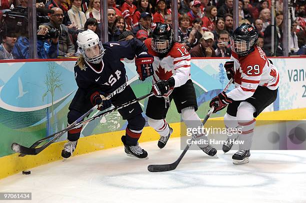 Monique Lamoureux of the United States is pursued by Meaghan Mikkelson and Marie-Philip Poulin of Canada during the ice hockey women's gold medal...