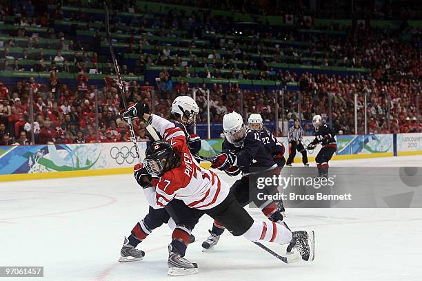 Cherie Piper of Canada is checked by Kerry Weiland of the United States during the ice hockey women's gold medal game between Canada and USA on day...