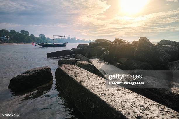 landscape of beautiful coast include in the beach with fishing boat are on the sea, blue sky and green mountain. - wiratgasem stock pictures, royalty-free photos & images