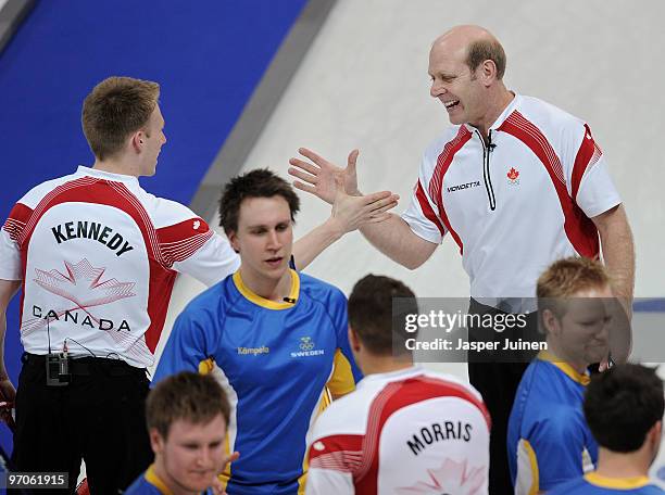 Skip Kevin Martin of Canada celebrates with his teammate Marc Kennedy at the end of the men's curling semifinal game between Canada and Sweden on day...