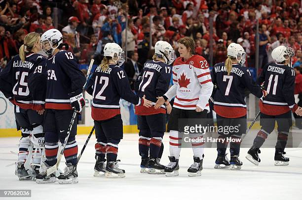 Hayley Wickenheiser of Canada shakes hands Team USA players following her team's 2-0 victory during the ice hockey women's gold medal game between...