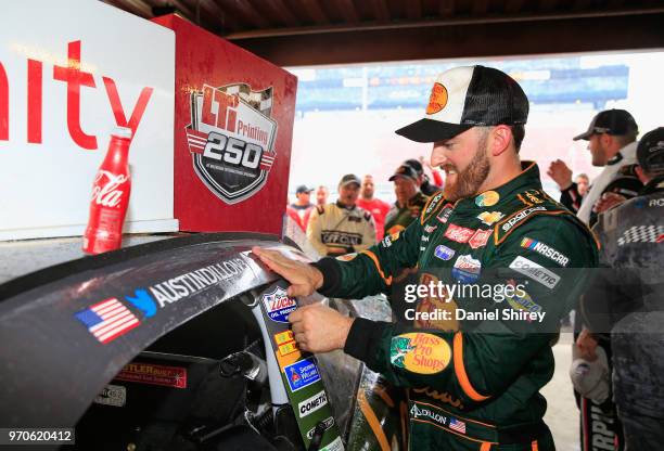 Austin Dillon, driver of the Bass Pro Shops/Cabela's Chevrolet, poses with the winner's sticker after the NASCAR Xfinity Series LTi Printing 250 at...