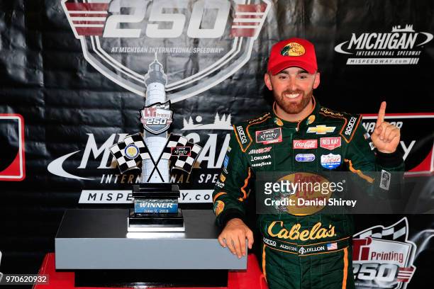 Austin Dillon, driver of the Bass Pro Shops/Cabela's Chevrolet, poses in Victory Lane after winning the NASCAR Xfinity Series LTi Printing 250 at...