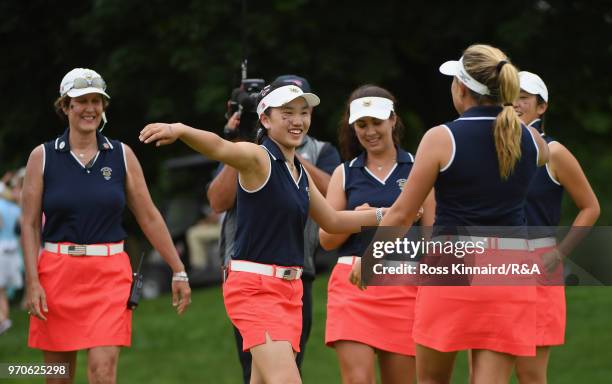 Lucy Li of the United States team celebrates with teammates as Captain Virginia Derby Grimes looks on from the 13th green during the afternoon...