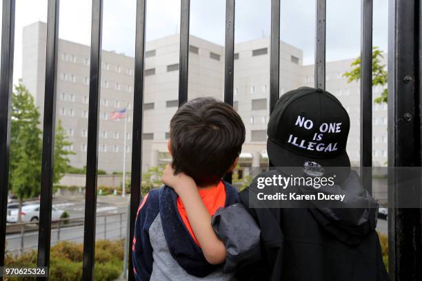 Javier Tapia , age 5, and his brother, Charlie Tapia, age 7, from Seattle, look at a Federal Detention Center holding migrant women on June 9, 2018...