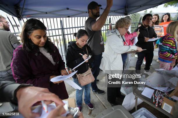 People write letters to local officials asking them to release parents imprisioned and reunite them with their children, during a rally outside the...