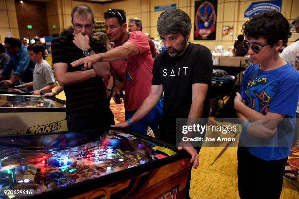 Tom Vixon 50, Longmont playing one of the new games, Iron Maiden, as his son Griffin 13, waits for his turn during the Rocky Mtn. Pinball Showdown...