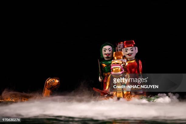 This picture taken on May 15, 2018 shows water puppets performing at the Thang Long theatre in Hanoi. - Vietnam is the birthplace of the...