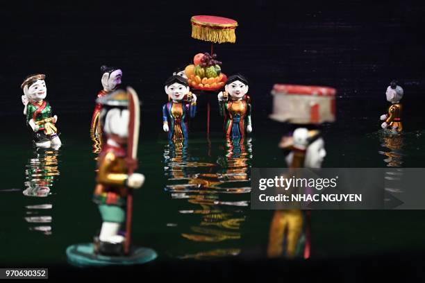 This picture taken on May 15, 2018 shows water puppets performing at the Thang Long theatre in Hanoi. - Vietnam is the birthplace of the...