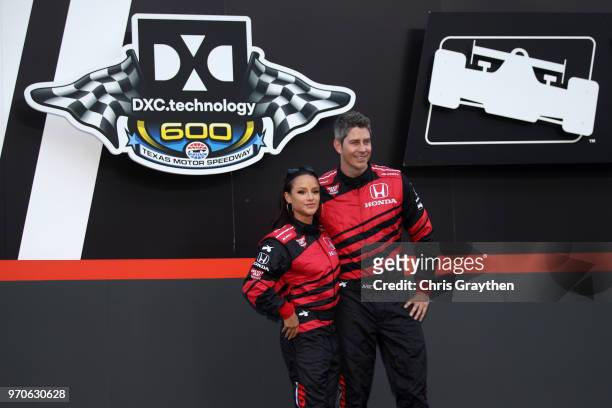 Jessica Graf poses with Arie Luyendyk Jr. On stage prior to the Verizon IndyCar Series DXC Technology 600 at Texas Motor Speedway on June 9, 2018 in...
