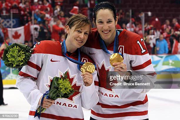 Jayna Hefford and Caroline Ouellette of Canada celebrate with the gold medals received following their team's 2-0 victory during the ice hockey...