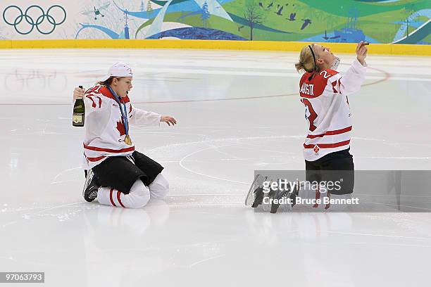 Haley Irwin and Meghan Agosta of Canada kneel on the ice and celebrate winning the gold medal with bubbly, beer and a cigar following their team's...