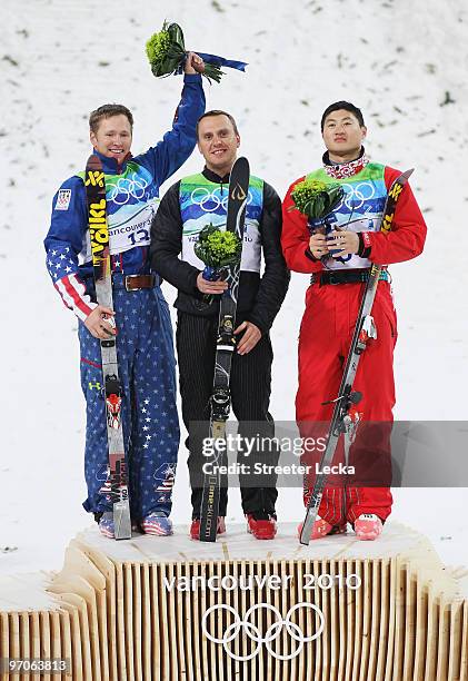 Silver medalist Jeret Peterson of the United States celebrates with gold medalist Alexei Grishin of Belarus and bronze medalist Liu Zhongqing of...