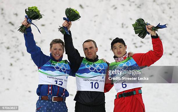 Silver medalist Jeret Peterson of the United States celebrates with gold medalist Alexei Grishin of Belarus and bronze medalist Liu Zhongqing of...