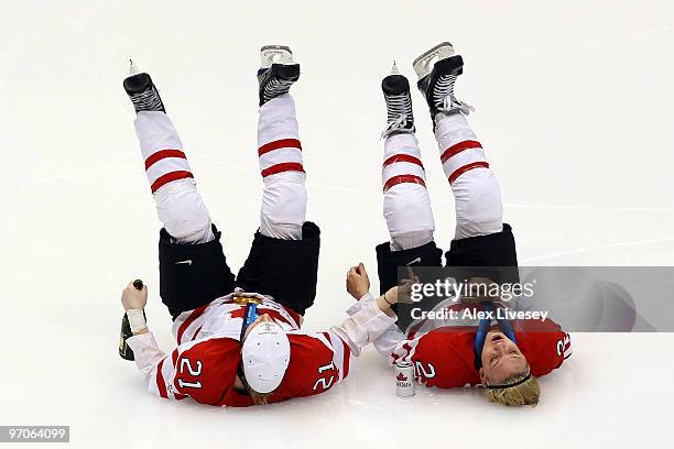 Haley Irwin and Meghan Agosta of Canada lie on the ice and celebrate winning the gold medal with bubbly, beer and a cigar following their team's 2-0...